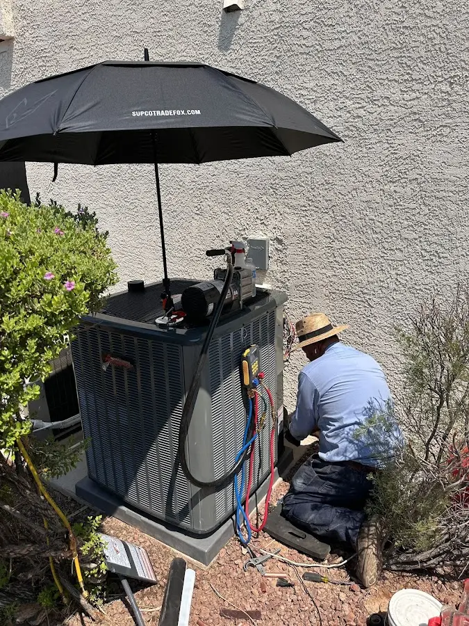 HVAC technician performing outdoor AC maintenance in Sunrise Manor